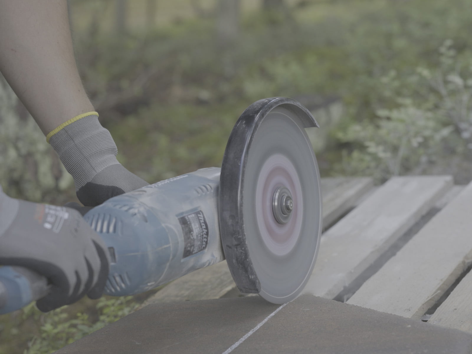 Raw, ungraded footage: an angle grinder cutting a paving stone